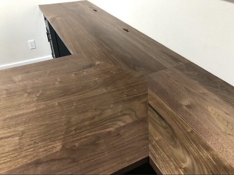  A closer shot showing the finished black walnut desktop and how the three sections come together. Custom slots were cut near the rear wall to allow for installation of the client’s monitor brackets.  
