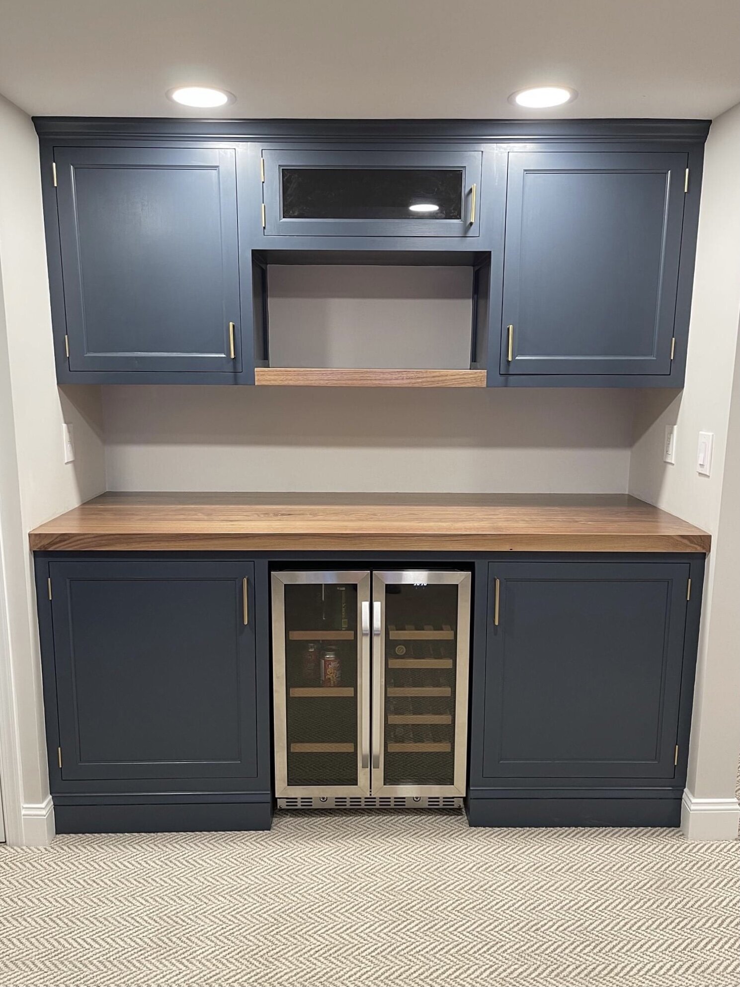  The finished project has inset flat panel doors, a black walnut countertop and shelf, and is painted in the Benjamin Moore color Hale Navy.   