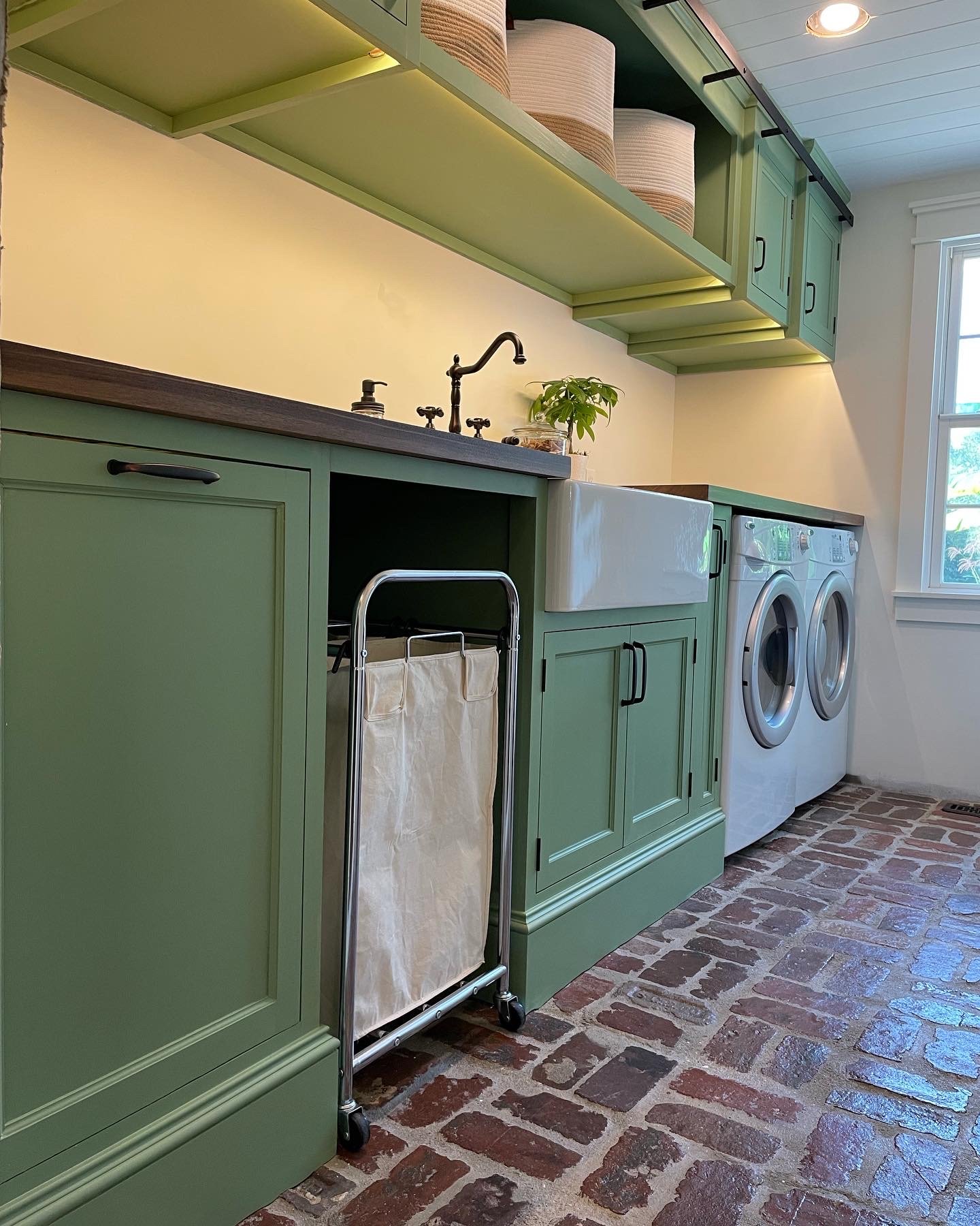  A large 30” farm sink provides ample room for soaking clothes, and next to the sink base is an open area for storing the laundry sorter.    