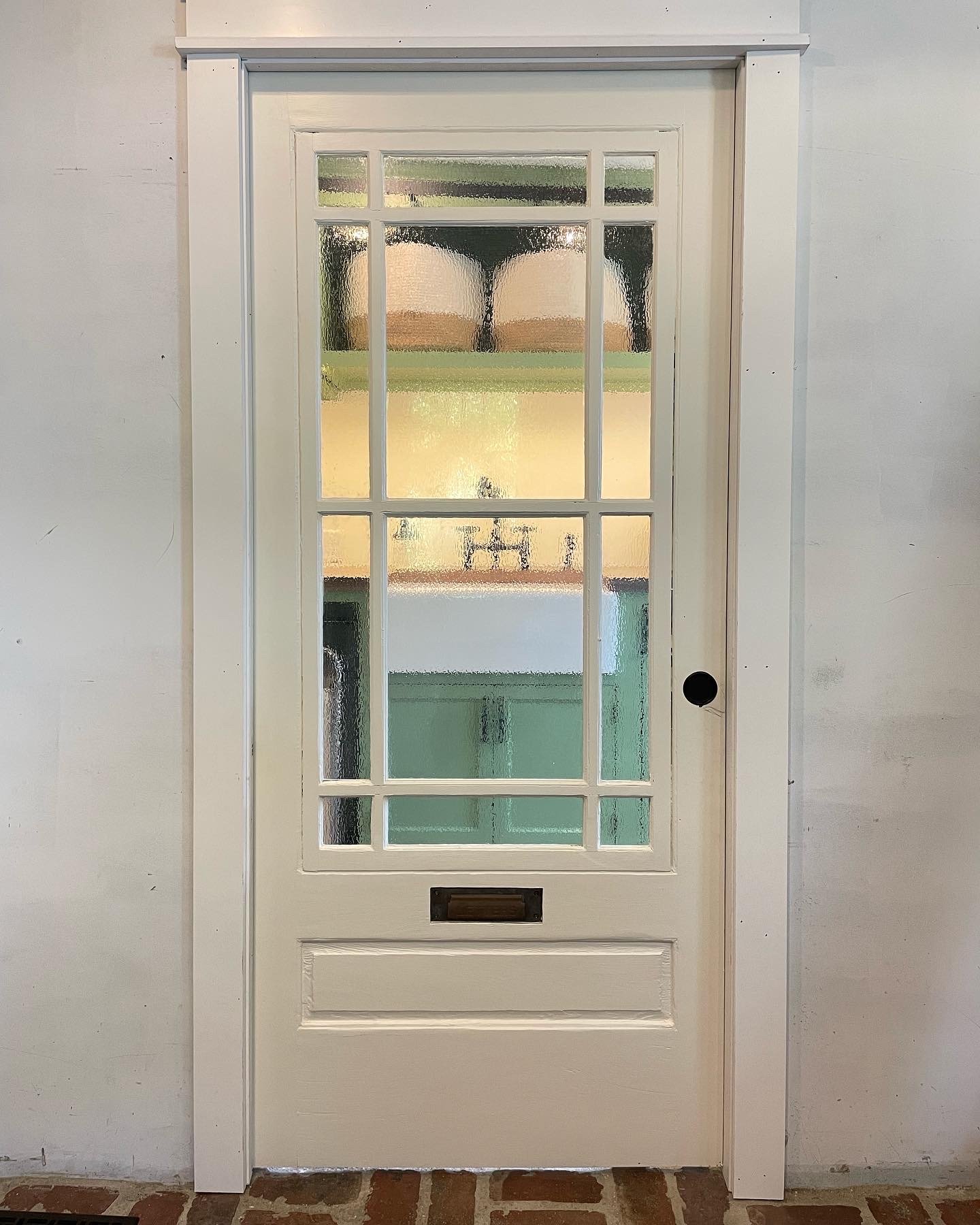  Between the laundry room and our mudroom, we installed this antique porch door as a pocket door. The original mail slot on the door added to the porch theme we were going for.   