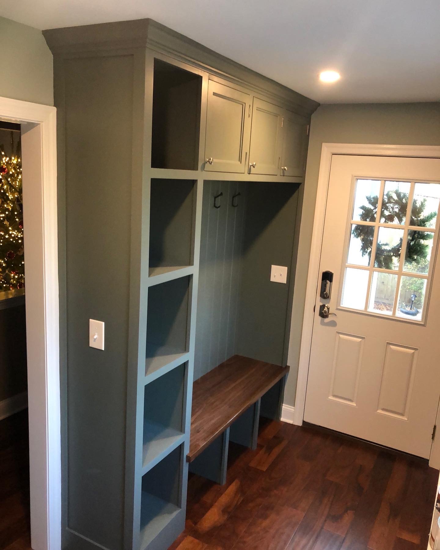  Here is the finished built-in unit. It features a black walnut bench, open shoe cubbies underneath, closed storage above, and a stack of additional cubbies on the side that were designed around baskets the client had picked out. 