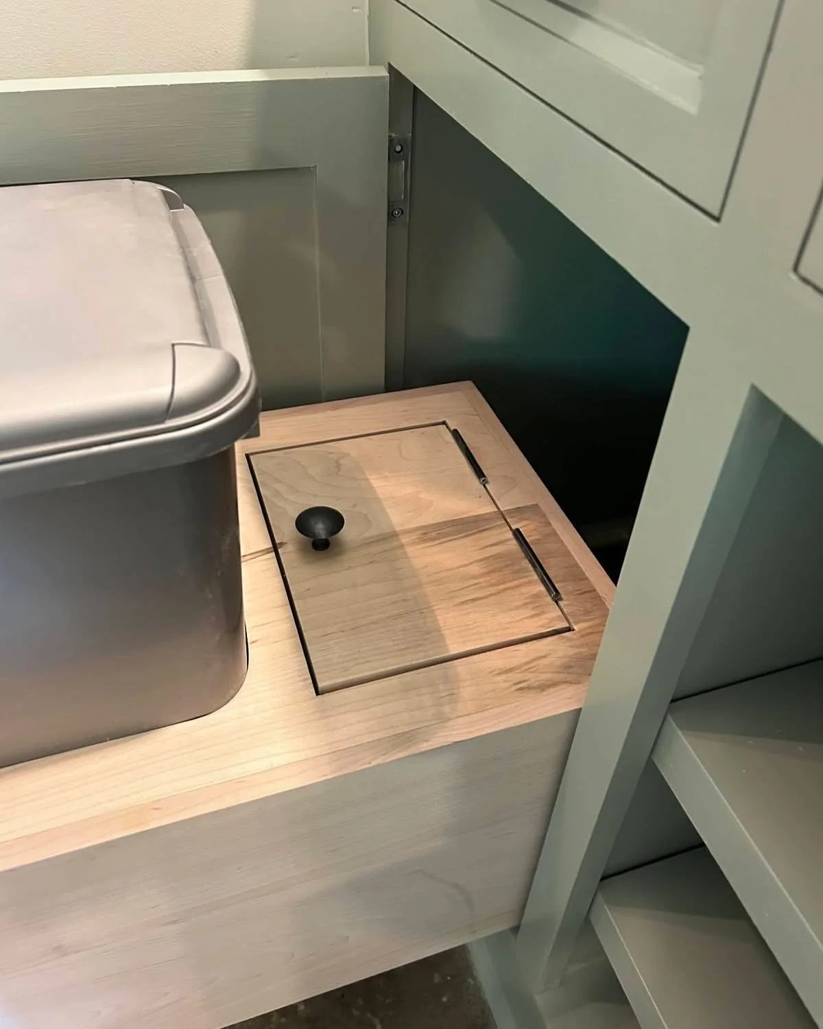  The small door behind the dog food container allows access to the interior of the drawer where small items can be stored. Cut from the original drawer top, the door grain matches its surroundings seamlessly.  