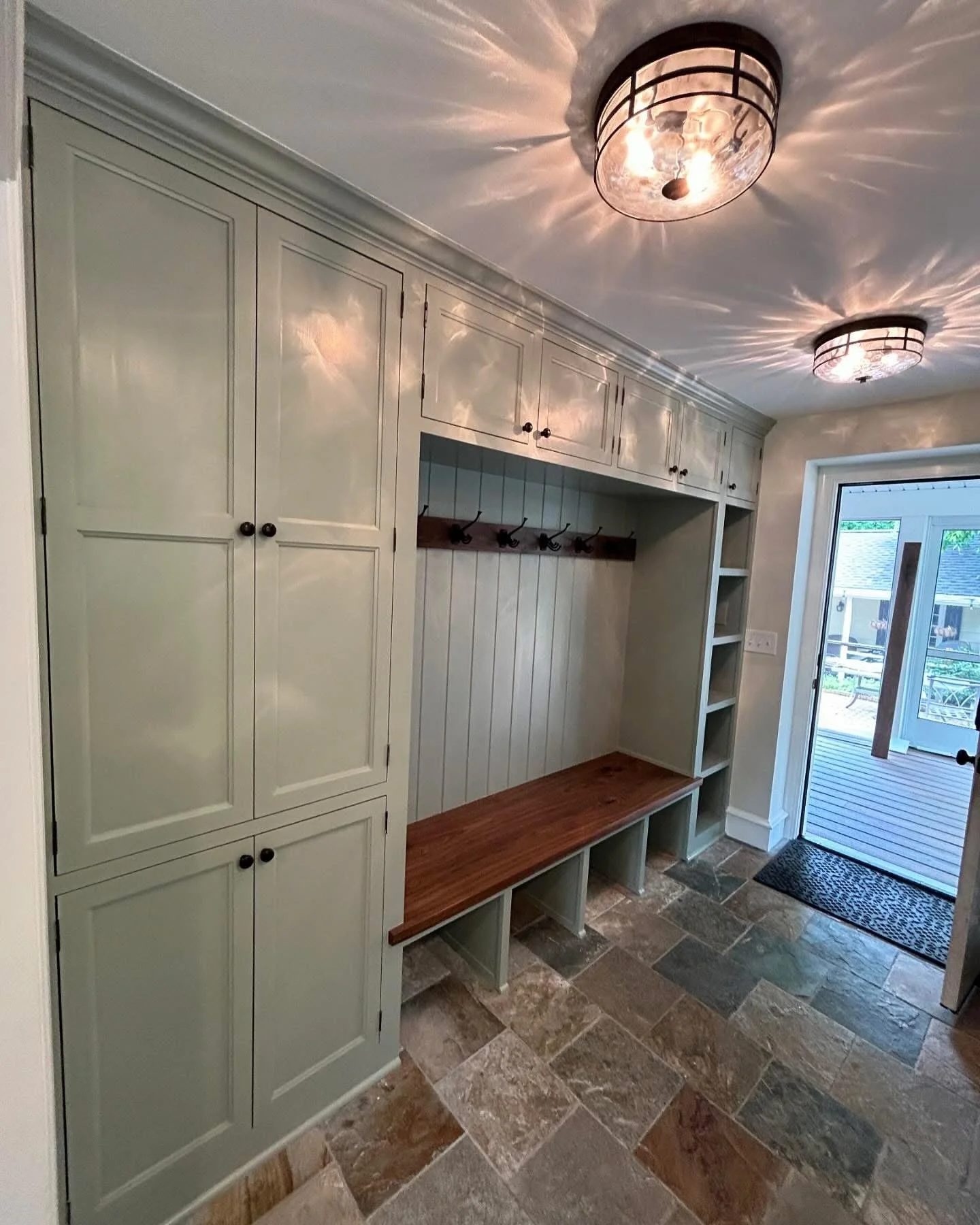  The overhead enclosed cabinets and open cubbies on the right, which are sized to fit baskets the client picked out, create a great spot for storing smaller items and seasonal things (gloves, hats, etc.) 