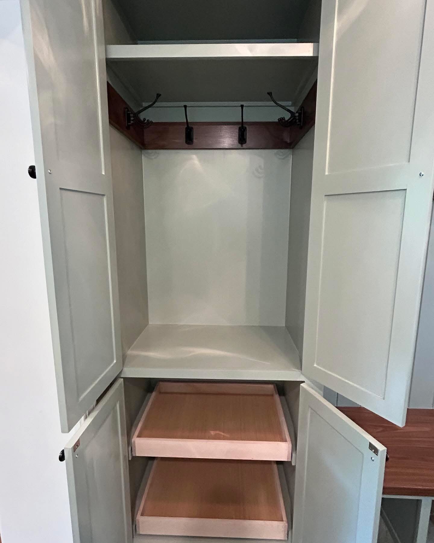  The tall cabinet on the far left boasts two pull out shelves in the bottom section and even more folding hooks in the upper portion.  
