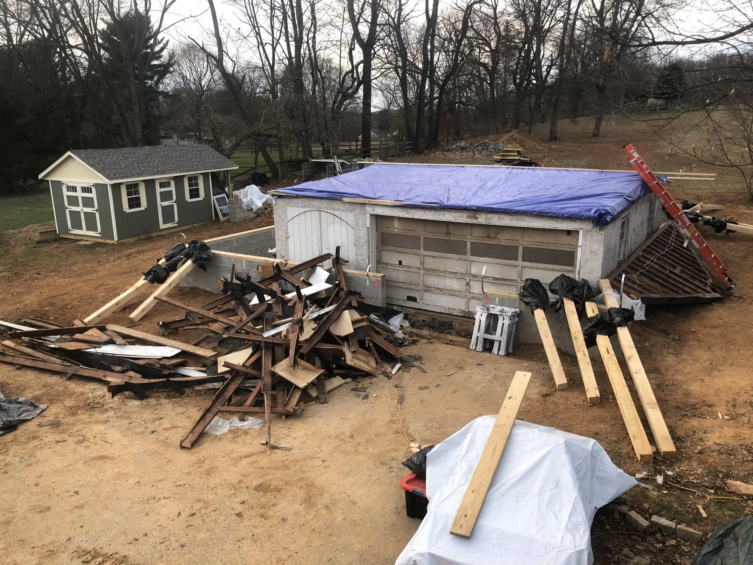  The timber frame kit was designed to go just above the walls of the original shop, so we removed the shop roof framing and tarped everything to keep everything dry inside.  