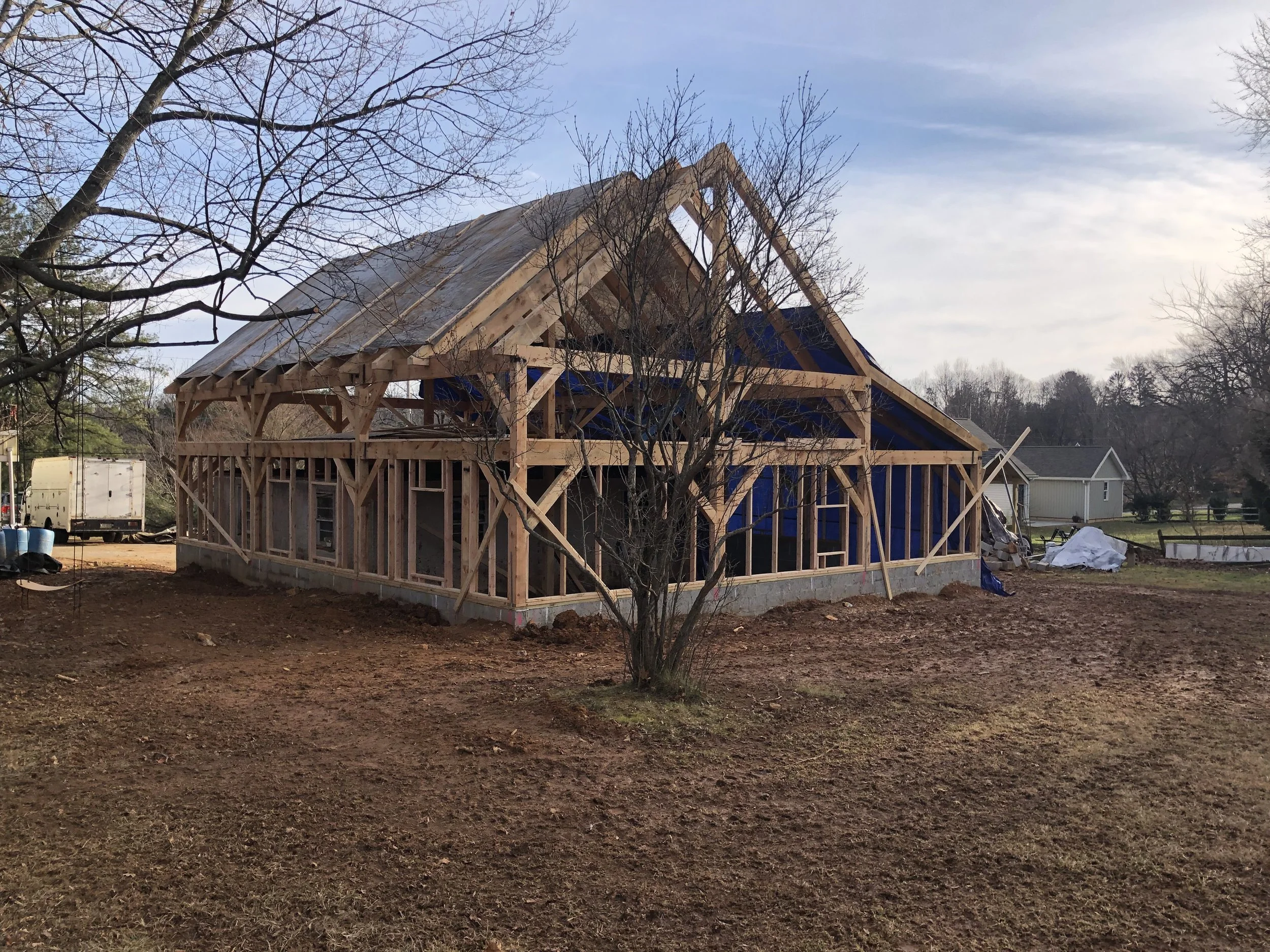  With the rafters in place we installed the in-fill framing on the first floor for windows, sheathing, etc. We also put some tarps up on the roof to help keep the rain and snow out.  