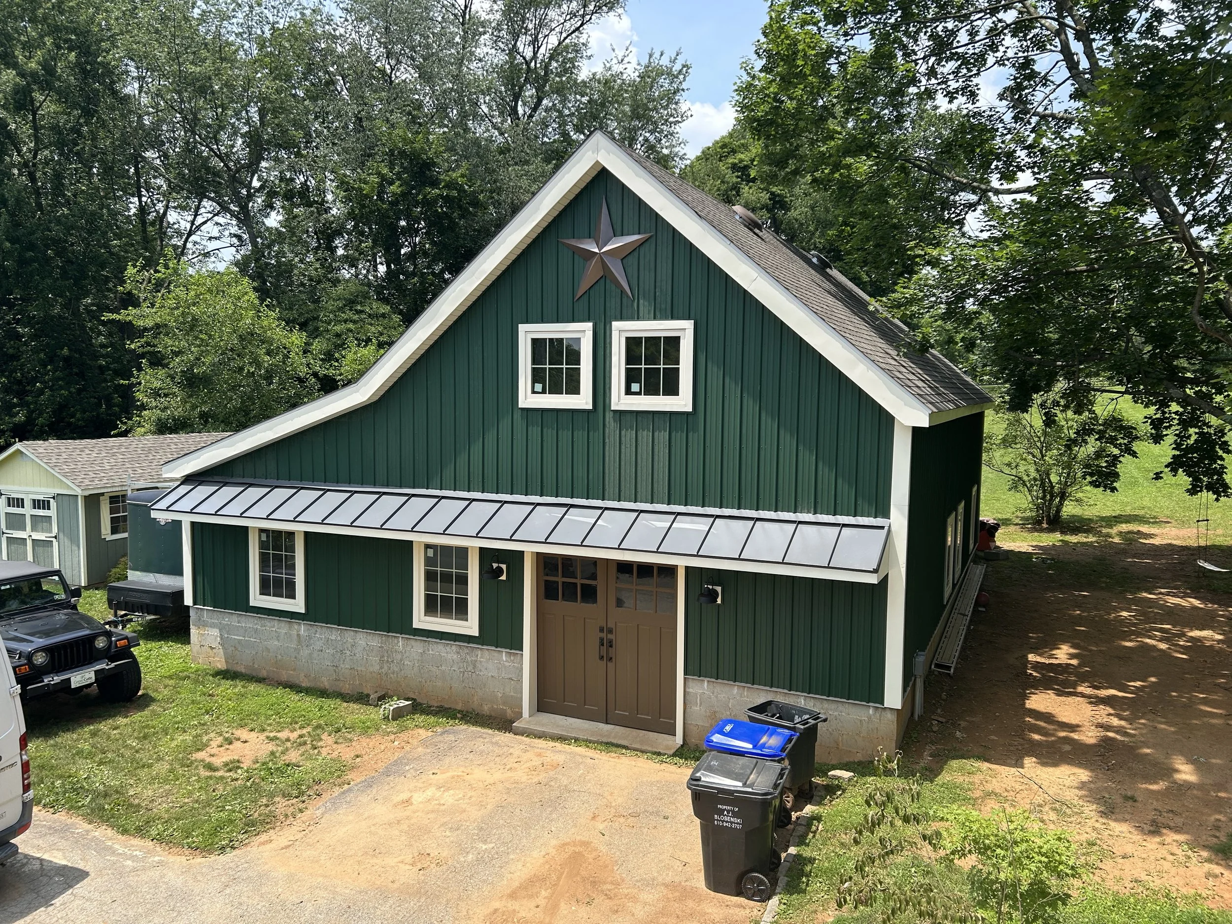  The “finished” shop as of the summer of 2025, next up will be installing gutters and then stone around the bottom of the walls to match  our house .  