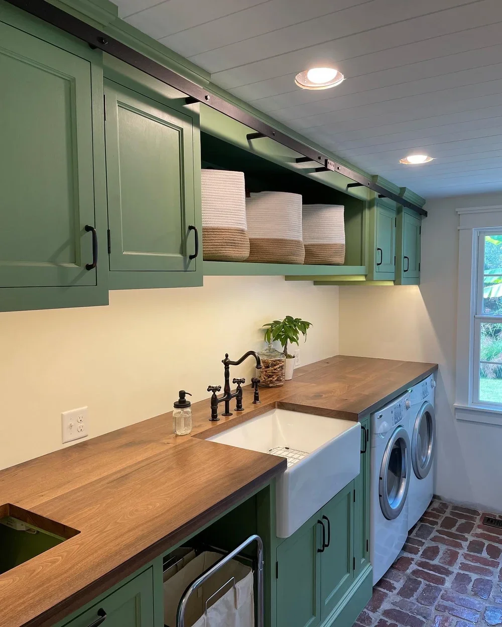  Our  laundry room,  just off the mudroom, has a black walnut countertop, large farm sink, custom cabinetry throughout, and a hidden laundry chute.  