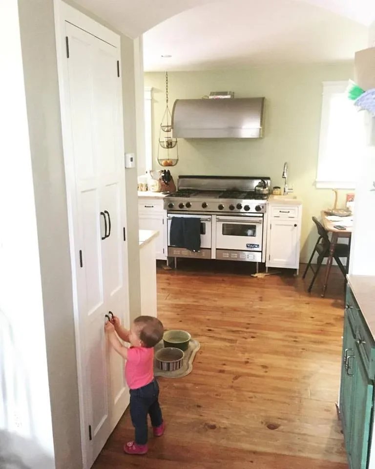  When I installed handles on the trash cabinet doors, I also installed a smaller pair down low for my kids to use. Here my younger daughter tests them out.&nbsp; 