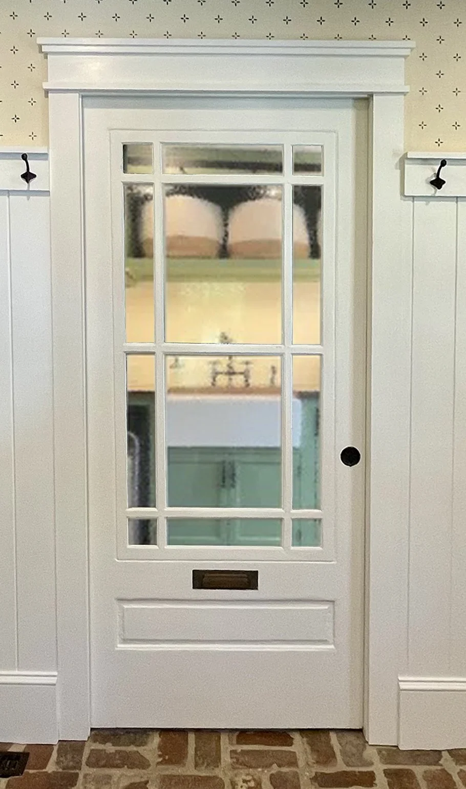  Between the laundry room and our mudroom, we installed this antique porch door as a pocket door. The original mail slot on the door added to the porch theme we were going for.   