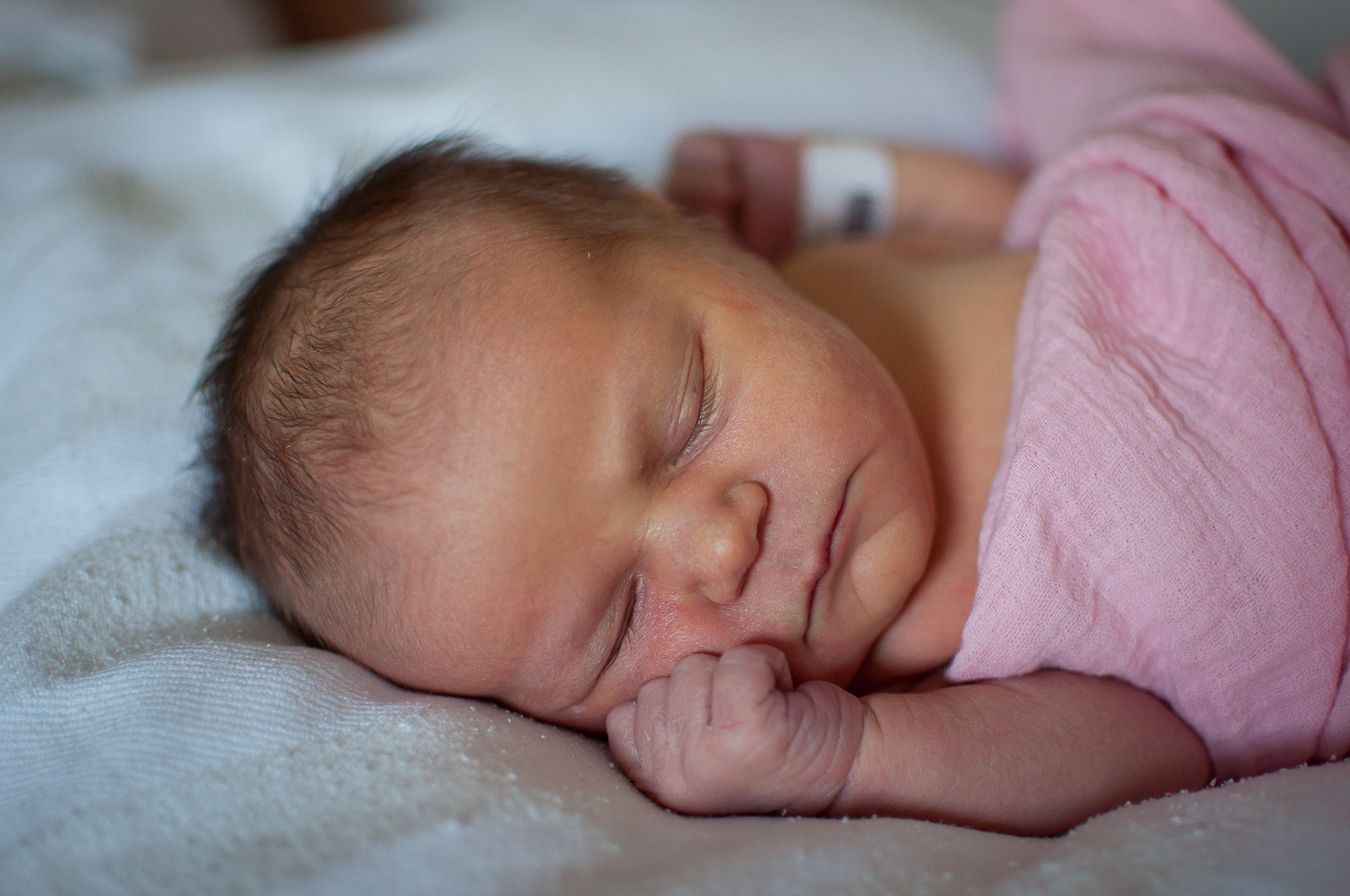Fresh 48 newborn lays on mom's bed at Pekin Hospital in Pekin IL.