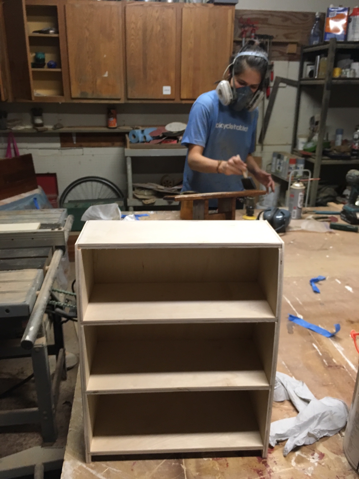 Spice rack just before being stained and sprayed. Really simple construction, just a few dados and rabbets, plus a gentle curve on the sides. Kristina is in the background brushing polyurethane onto one of our meditation stools that just sold. 