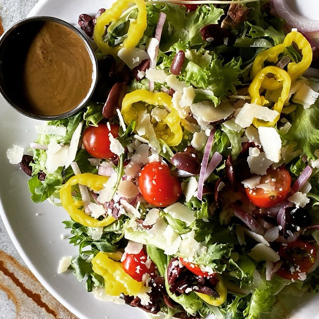 Our Italian Salad Is fresh and flavorful! Romaine, tomato, red onion, banana peppers, Kalamata olives, Parmesan &amp; basil balsamic vinaigrette. Make it a satisfying meal - add wood-fired chicken! Available only at our @westsidebrewing location.