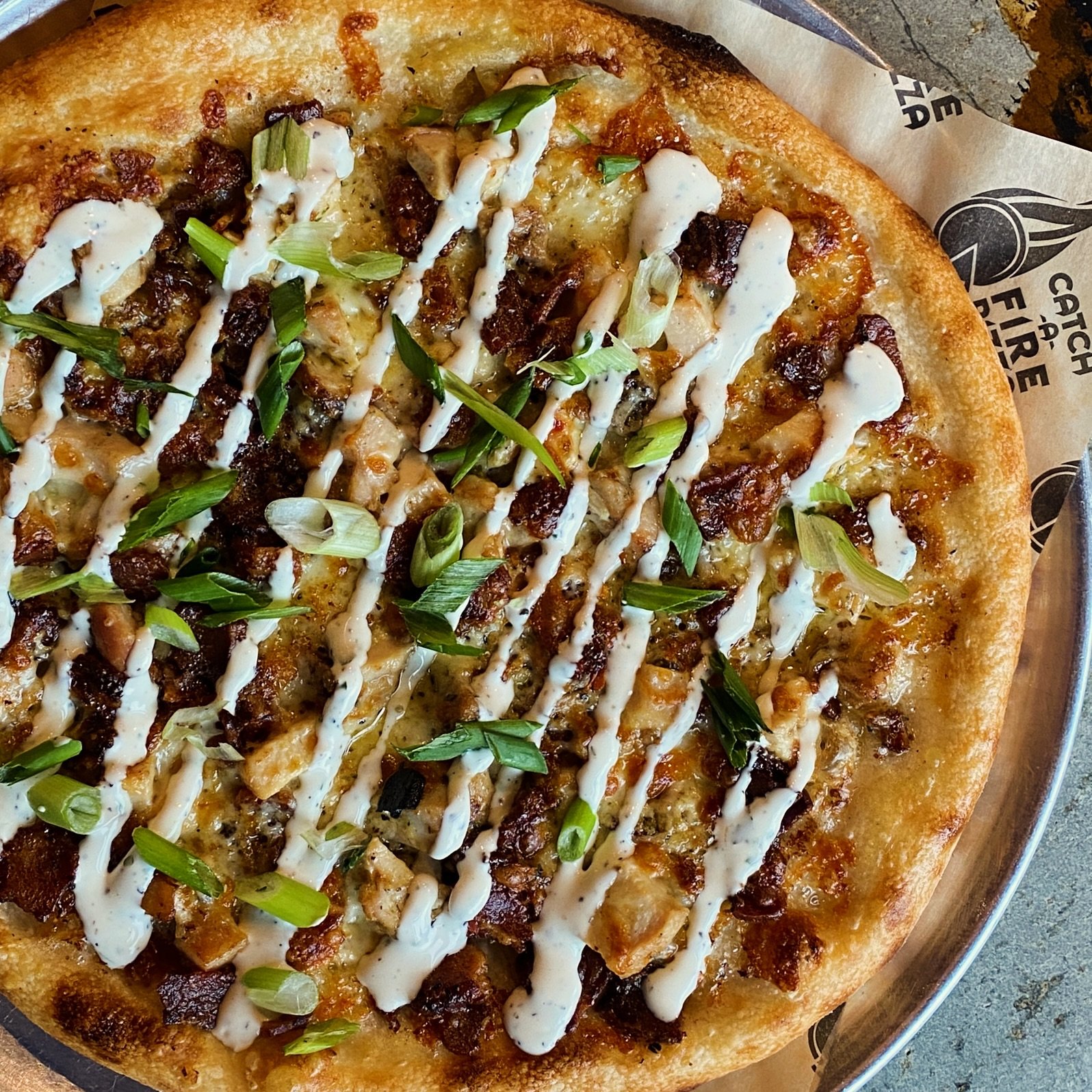 Rebel Ranch pizza -hand tossed dough brushed with garlic butter, topped with chicken, bacon, four cheeses, white cheddar, scallions &amp; ranch- you&rsquo;re probably going to want to ask for a side of ranch for dipping those slices! #extraranchpleas