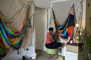 Amber Robles-Gordon works in the living room of her Anacostia home. Gordon earned an Master of Fine Arts degree from Howard University.