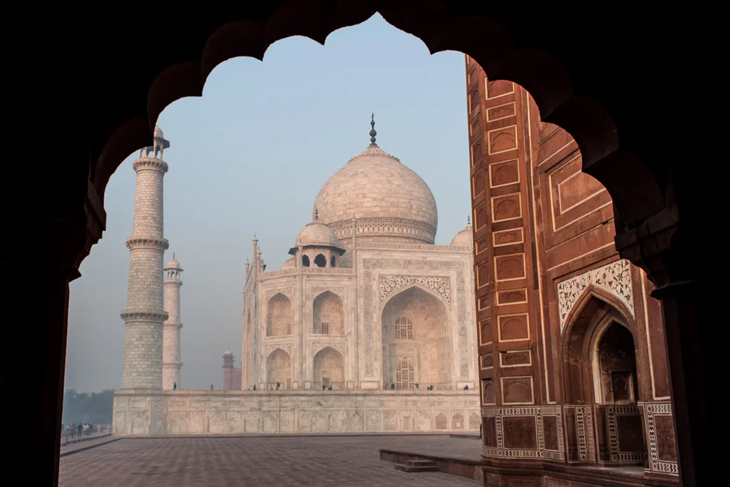 Standing under the gorgeous arches at the wall to the right of the Taj Mahal.