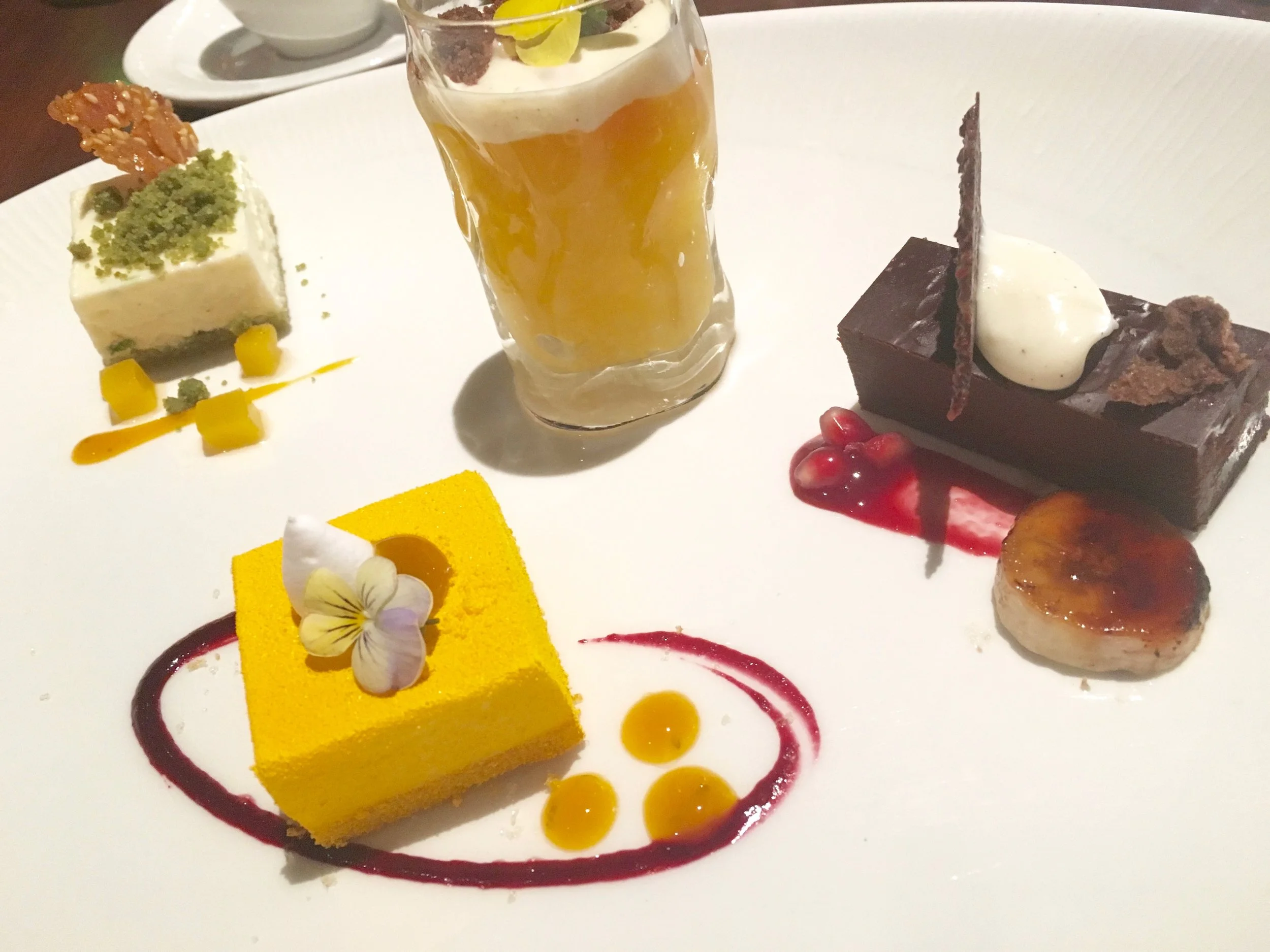 Petite versions of desserts. Don't make me label which is which. The four are calamansi mousse with mango lava and Swiss meringue, lime cheesecake with almond-sesame tuile and green tea sponge, passion fruit tapioca creme with chocolate crumble and citrus fruits, and South American chocolate ganache with caramelized banana and cocoa nib tuile at Tiffins