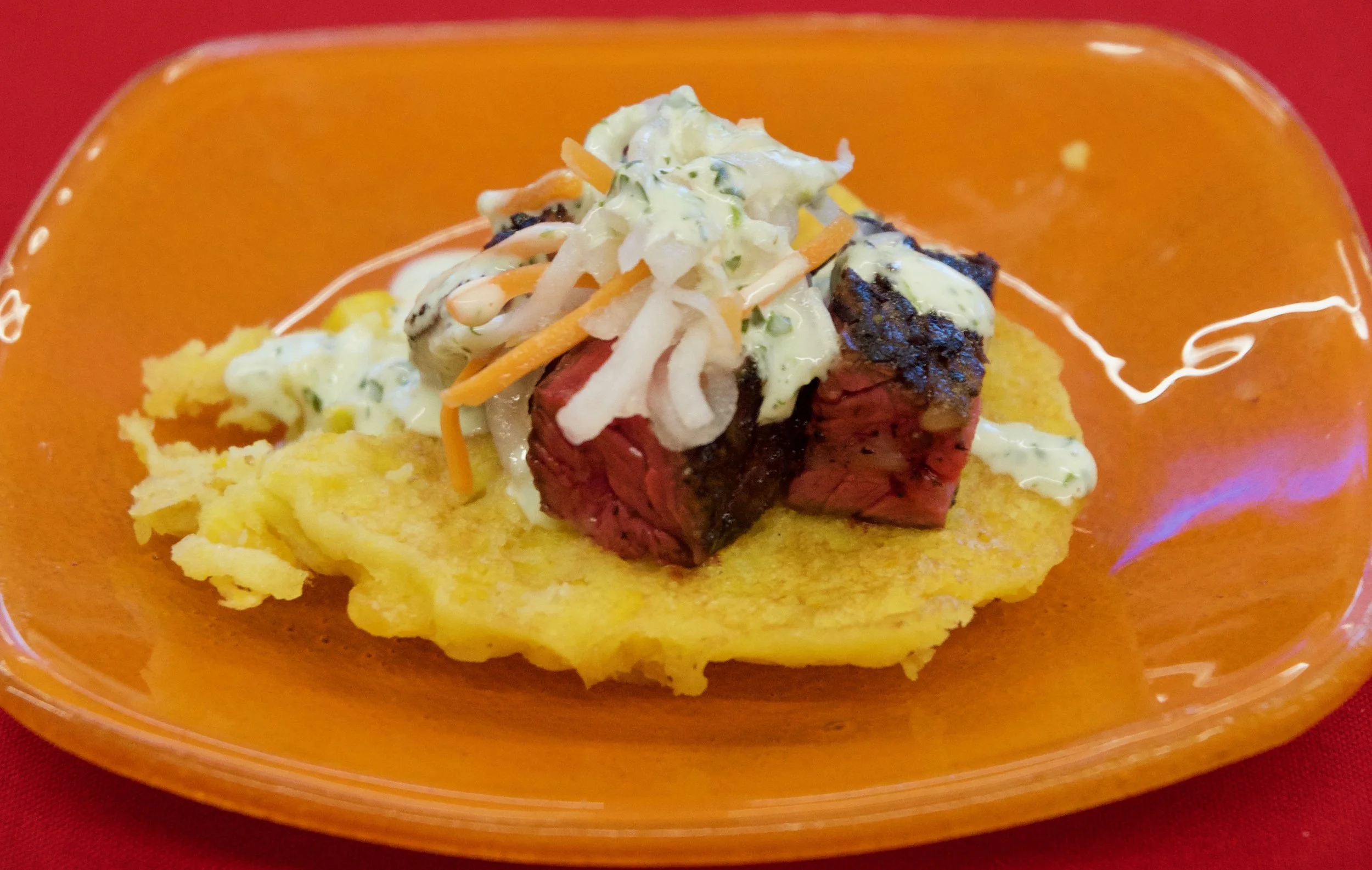 Charred chimichurri skirt steak on a smoked corn cake