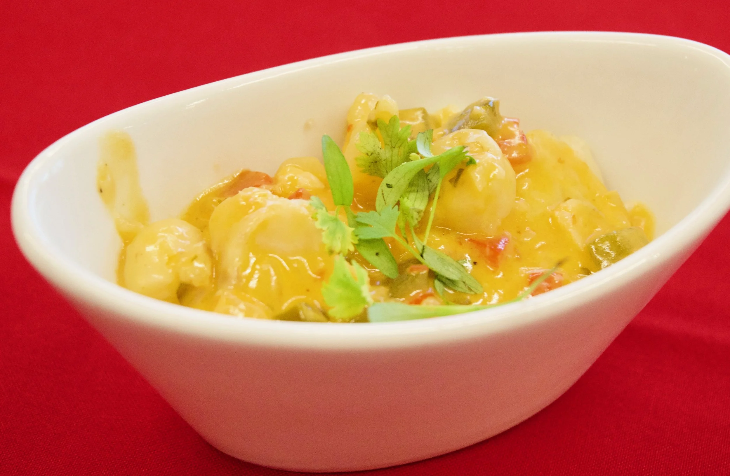 Give yourself a spell of Brazil by snacking on this spicy seafood stew. It's called moqueca , and it's made with scallops, shrimp and white fish simmered in a coconut-lime sauce and served atop rice.
