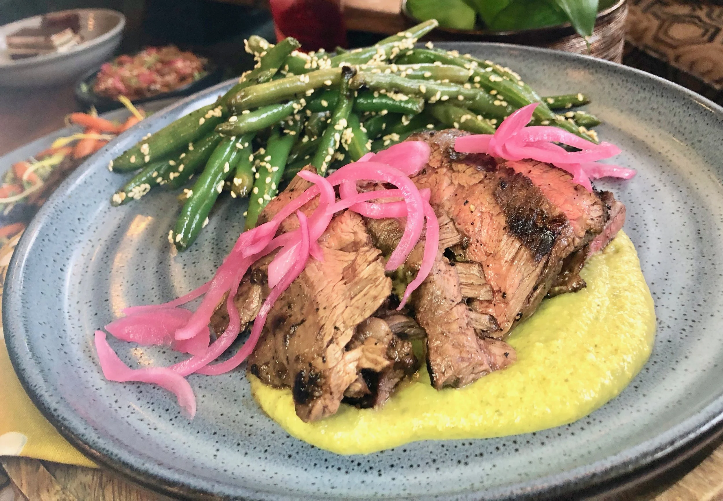 Reyes Mezcaleria – Churrasco Steak. This is grilled Latin American steak in fine, fine form – so good that every time I took another slice I’d get the evil eye from otherwise friendly co-diners. There wasn’t enough for us to eat hearty portions, and we all loved it so much we kept refilling our plates with little slices so as not to finish it up. Here the grilled skirt steak is served with “pipian” verde sauce (pumpkin seeds!) along with charred green beans (also delicious) and pickled red onion.