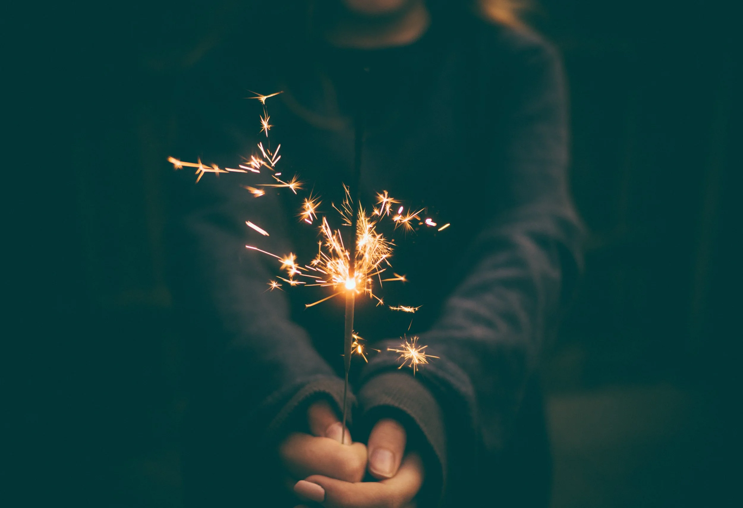 a person holds a sparkler in their hands
