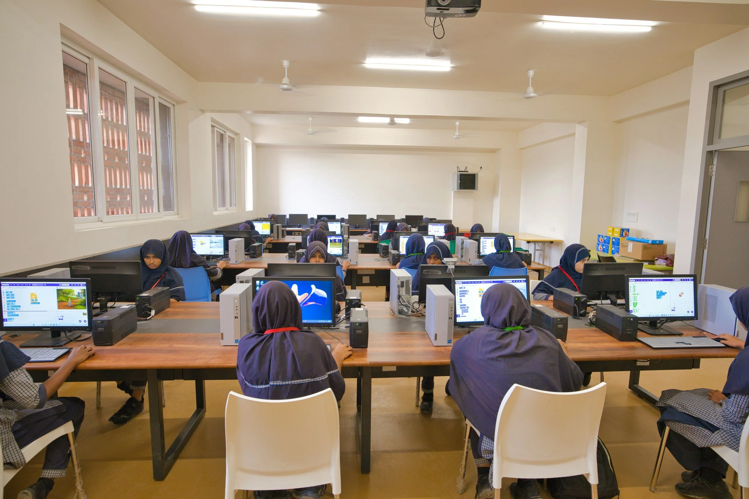 a computer lab with high schoolers using the desktop computers
