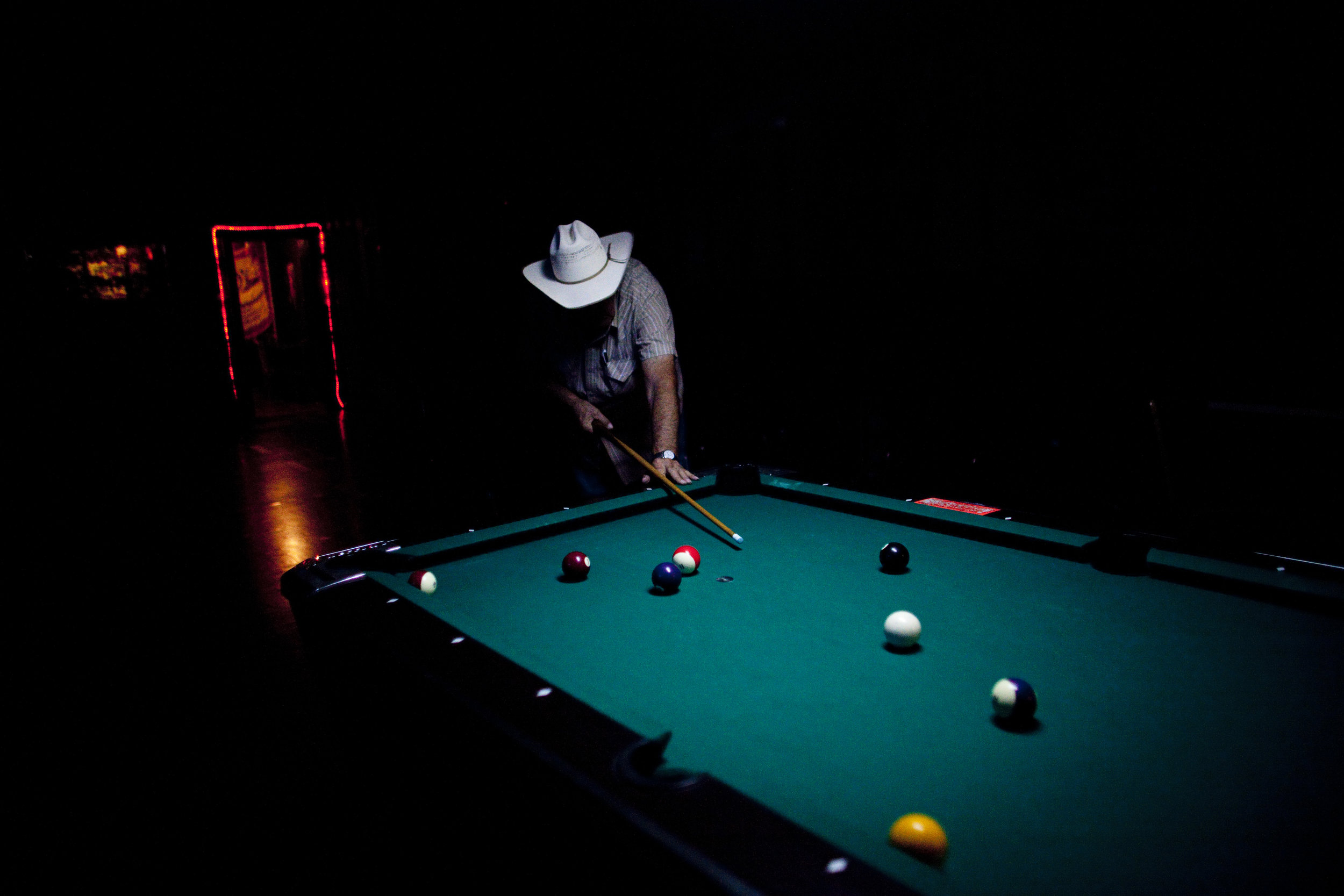  George Sherman, who ran George's Corner Bar in Valentine, plays pool with the few patrons he has on an autumn night.&nbsp;The bar was sold and is now much cleaner, brighter and renamed "The Corner Pub." 