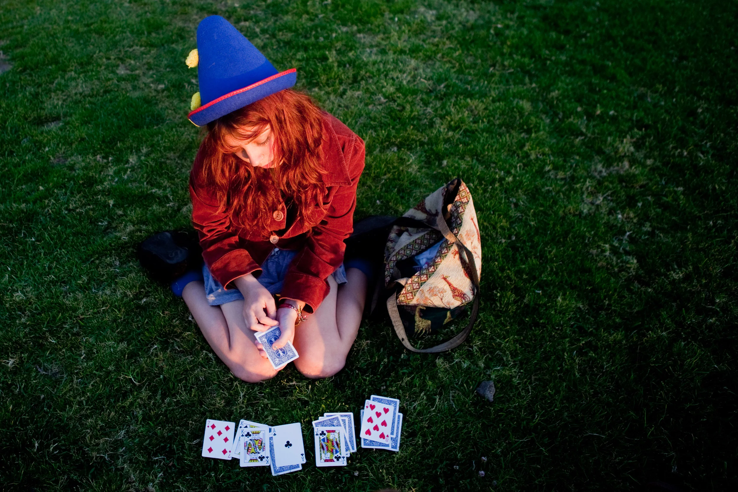 Echo plays a card game on the grassy area near the pier in San Clemente, California. Grass is sparse in the town, and there are often high schoolers taking advantage of the green commodity by the pier.