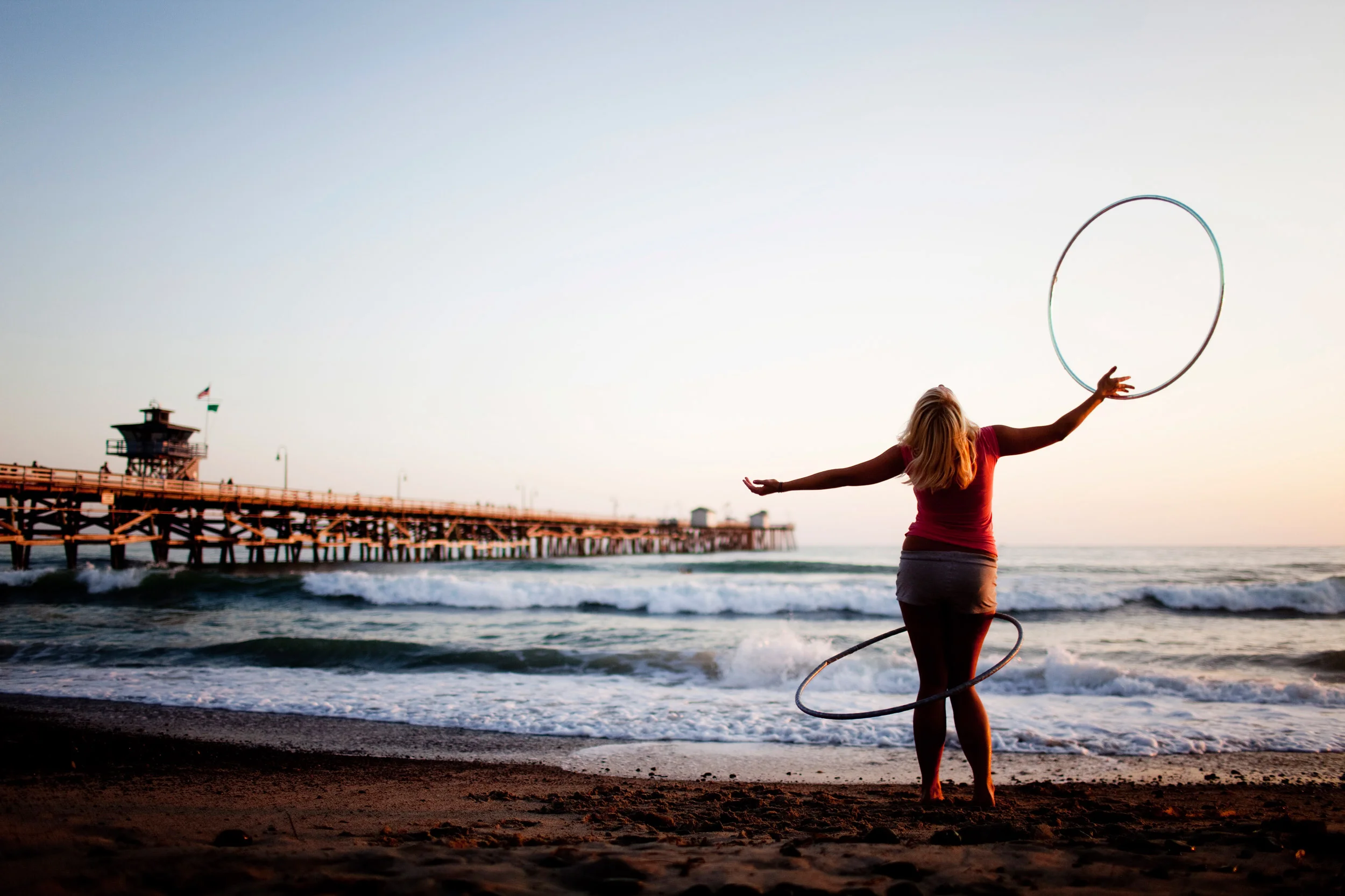 Claire Bush practices hula hooping by the pier in San Clemente, California. Bush said she hula-hoops almost every day, and enjoys practicing near the ocean.