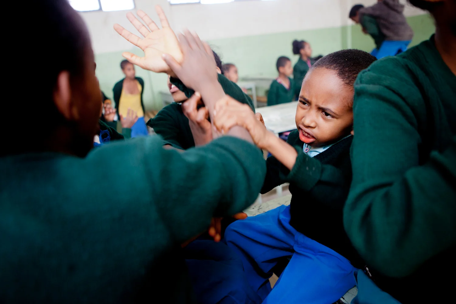  Sisay tries to keep other kids from touching him while students play during a break in class in May 2013. 