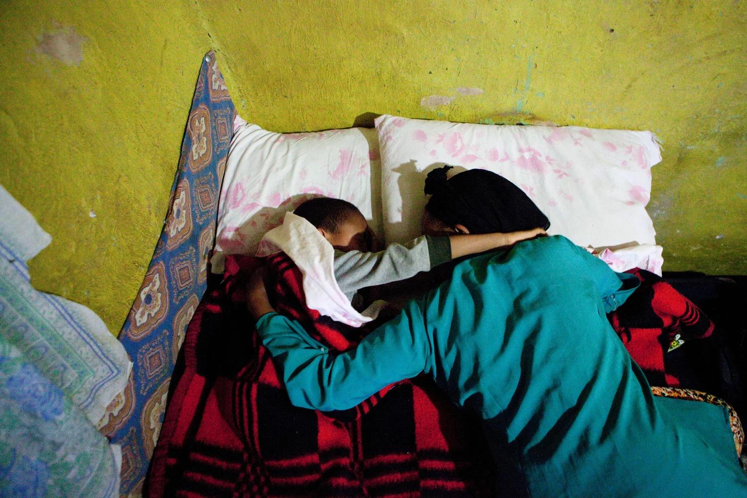  Abonesh,&nbsp;Sisay's mother, hugs him before he sleeps in the bed that they share. He would be away from her for six months when Dr. Hodes sends him to Accra, Ghana, to receive the life-saving treatment and surgery he needs. 