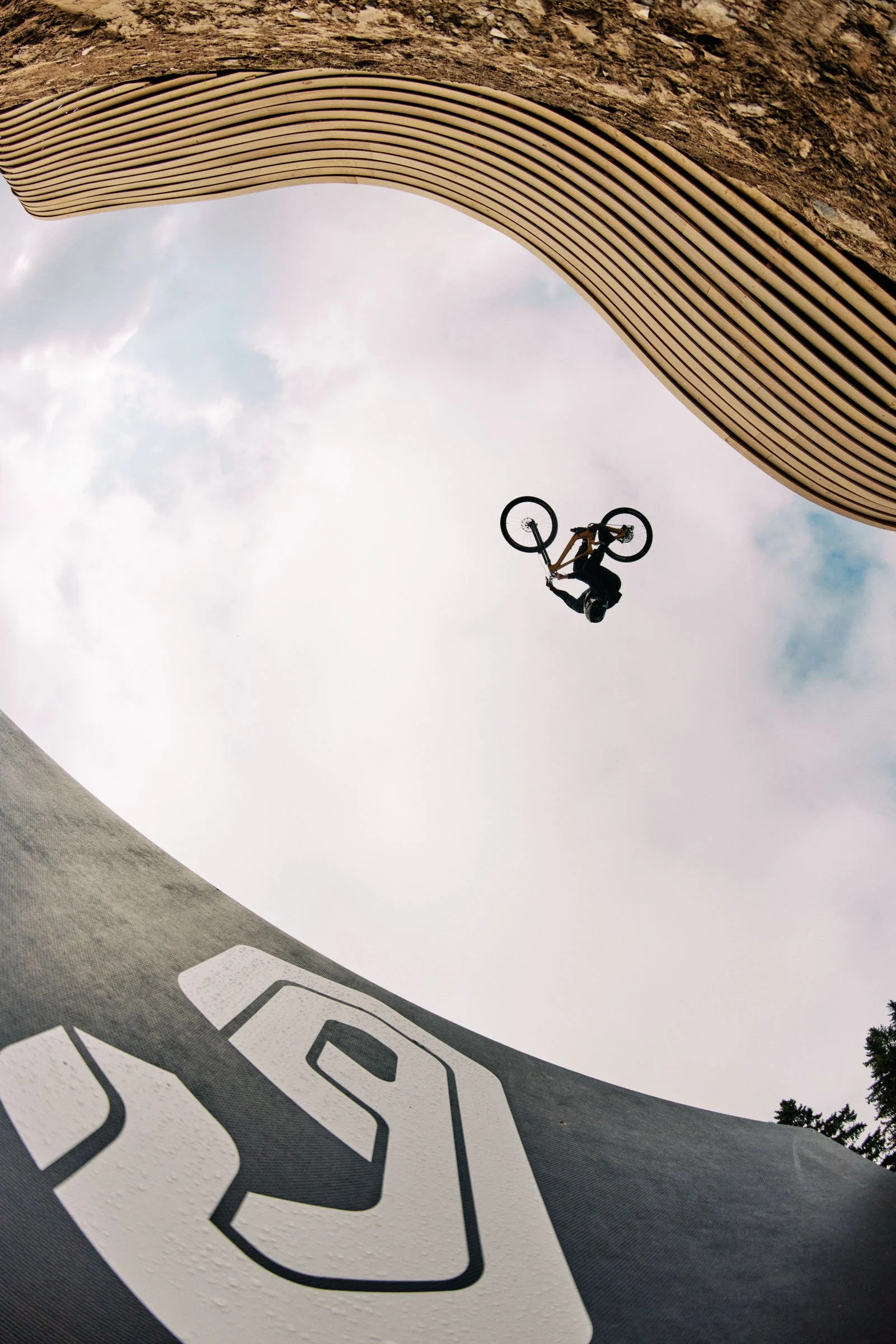 A person performing a mid-air BMX stunt over a skatepark ramp.