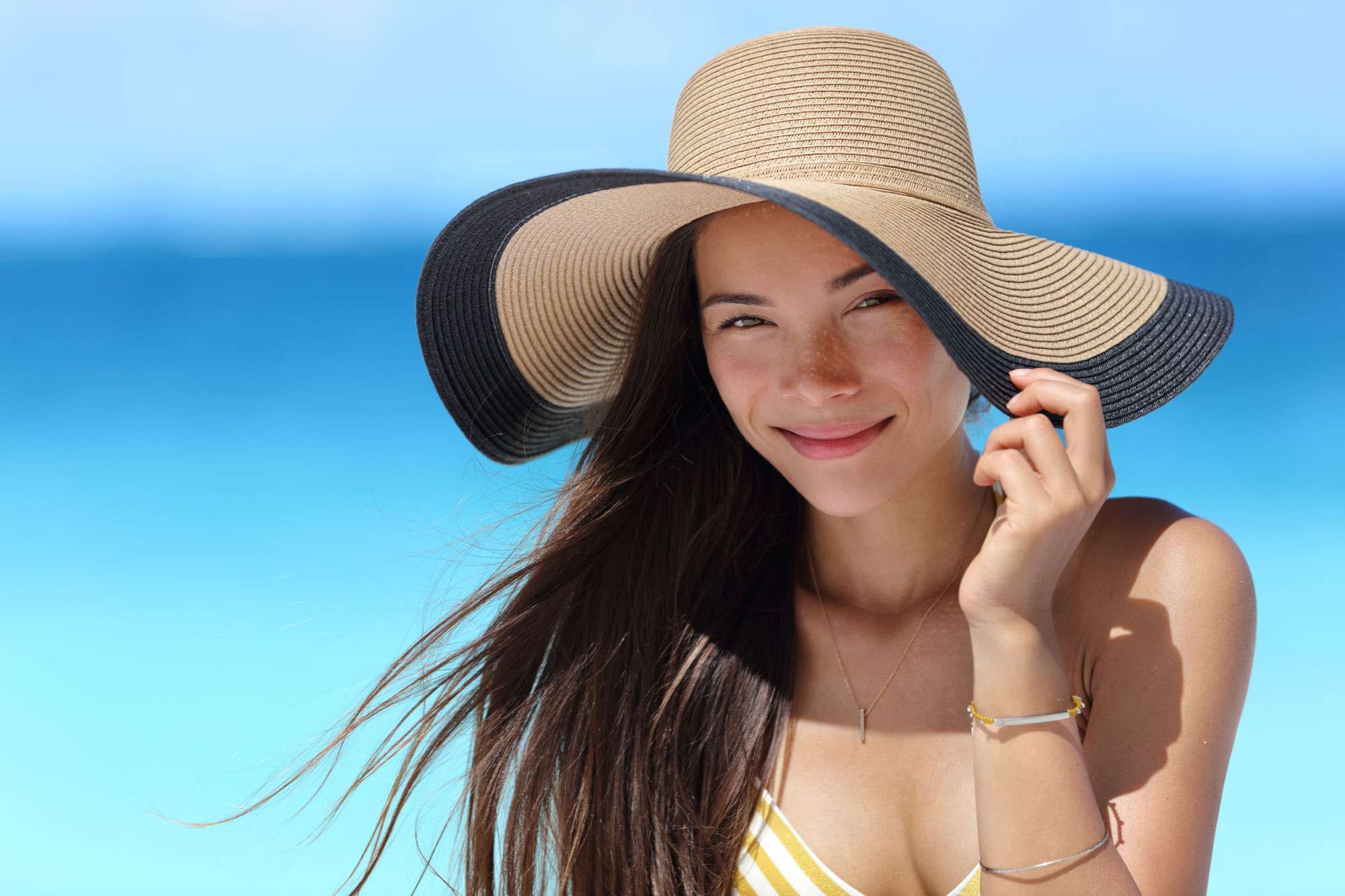 Asianwomanwithbeachhatforfacesunprotection.jpg