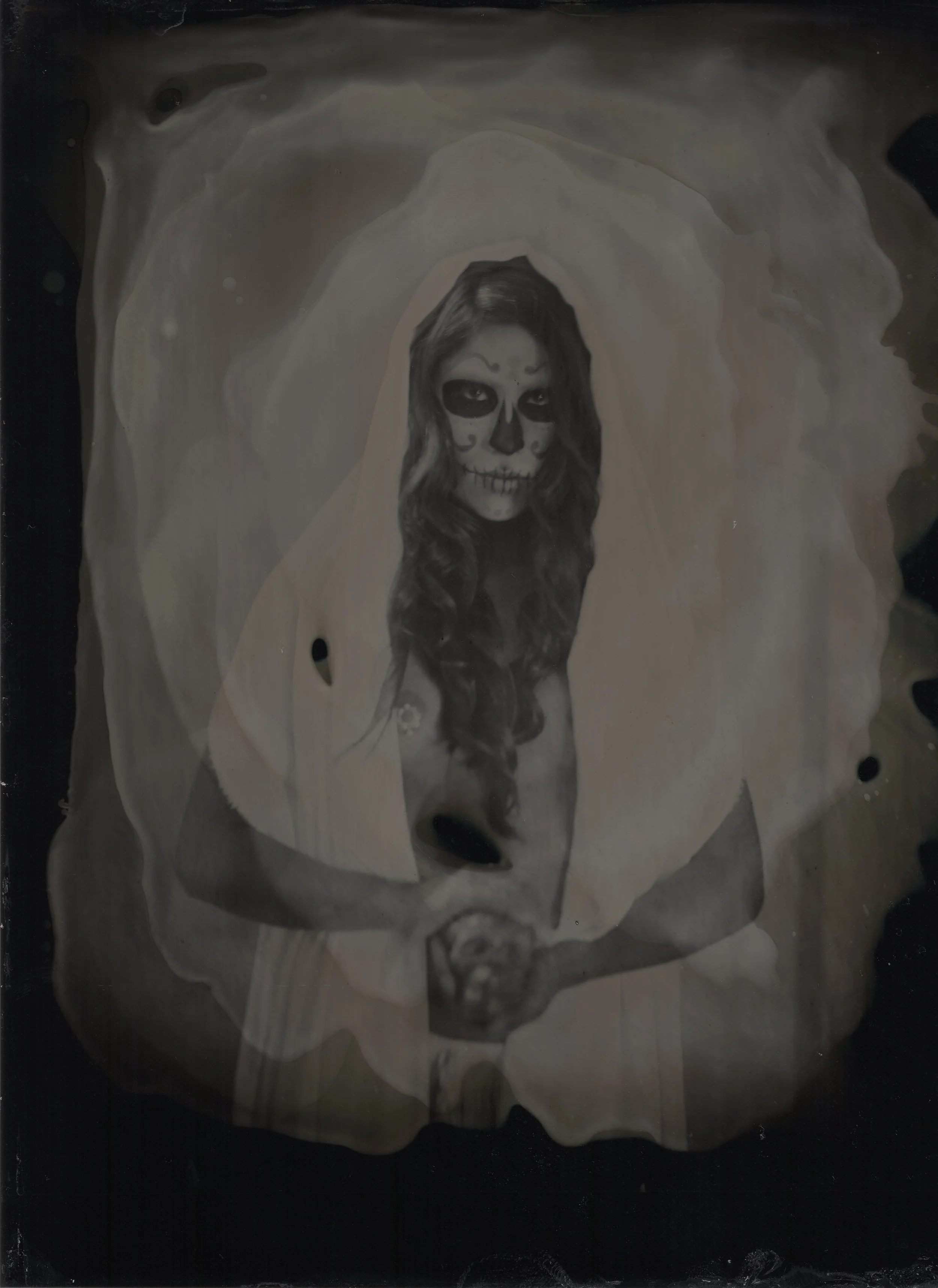 When talking to Photographer Dana Rogers about doing a tintype photo shoot with makeup I knew I wanted to do something fitting with the look and style that would fit. I wanted to do something timeless, something that looked like it existed when the camera was made back in the 1870's. It didn't take us long to land on Dia De Los Muertos or Day of the Dead. I knew straight away that I wanted to use a Mexican model to keep things as authentic as possible. With my good friend and model Casandre Elyse Medel coming in town from Colorado we had one day to get it right. The weather was perfect and watching Dana work was like magic. Tintype photography is such an interesting and beautiful process. This image are scans of the original because the original is one of a kind. I did this really pretty DOTD makeup with a color pallet I loved using lime greens, yellow, greys, black and white knowing it would be lost in black and white. At first I was a bit disappointed that no one would see that pallet but after I saw the first image processed I could not have been happier. It was like taking a trip in a time machine. I hope you enjoy.