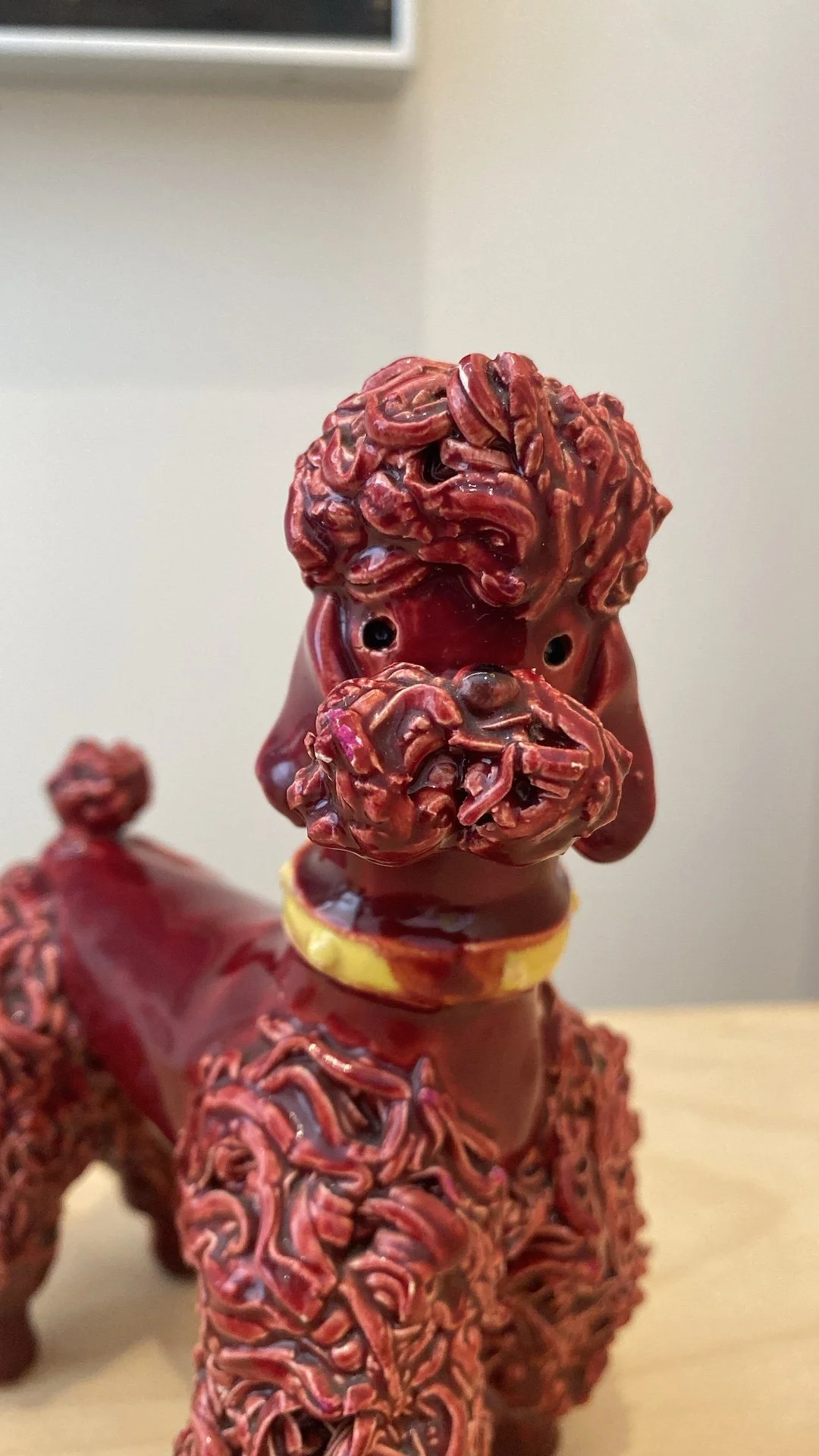 Small ceramic spaghetti poodle made in France, maroon glaze with yellow collar