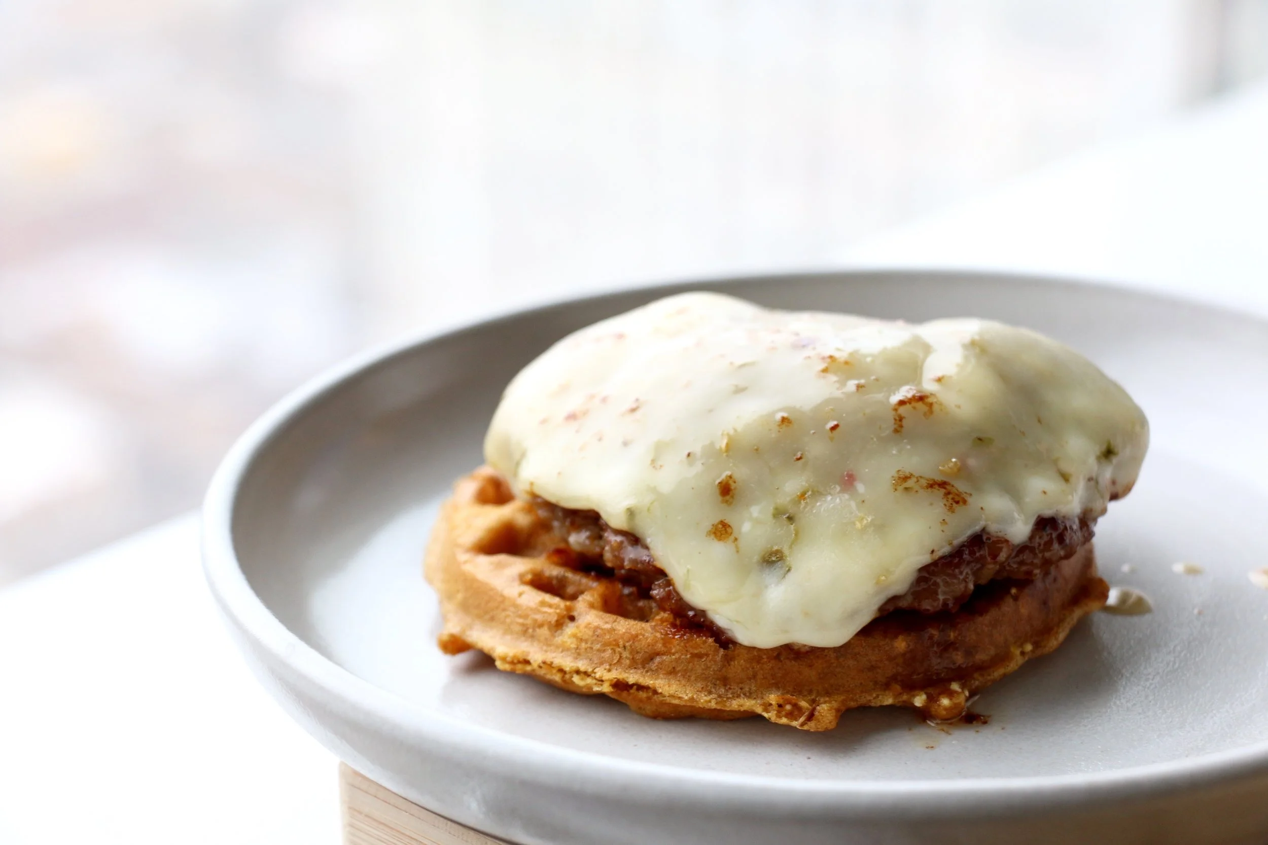 Layer the juicy sausage patty with melted pepper jack onto the waffle. Drizzle some of that lovely sausage grease/fat from the pan on top of the cheese for added moisture and flavor