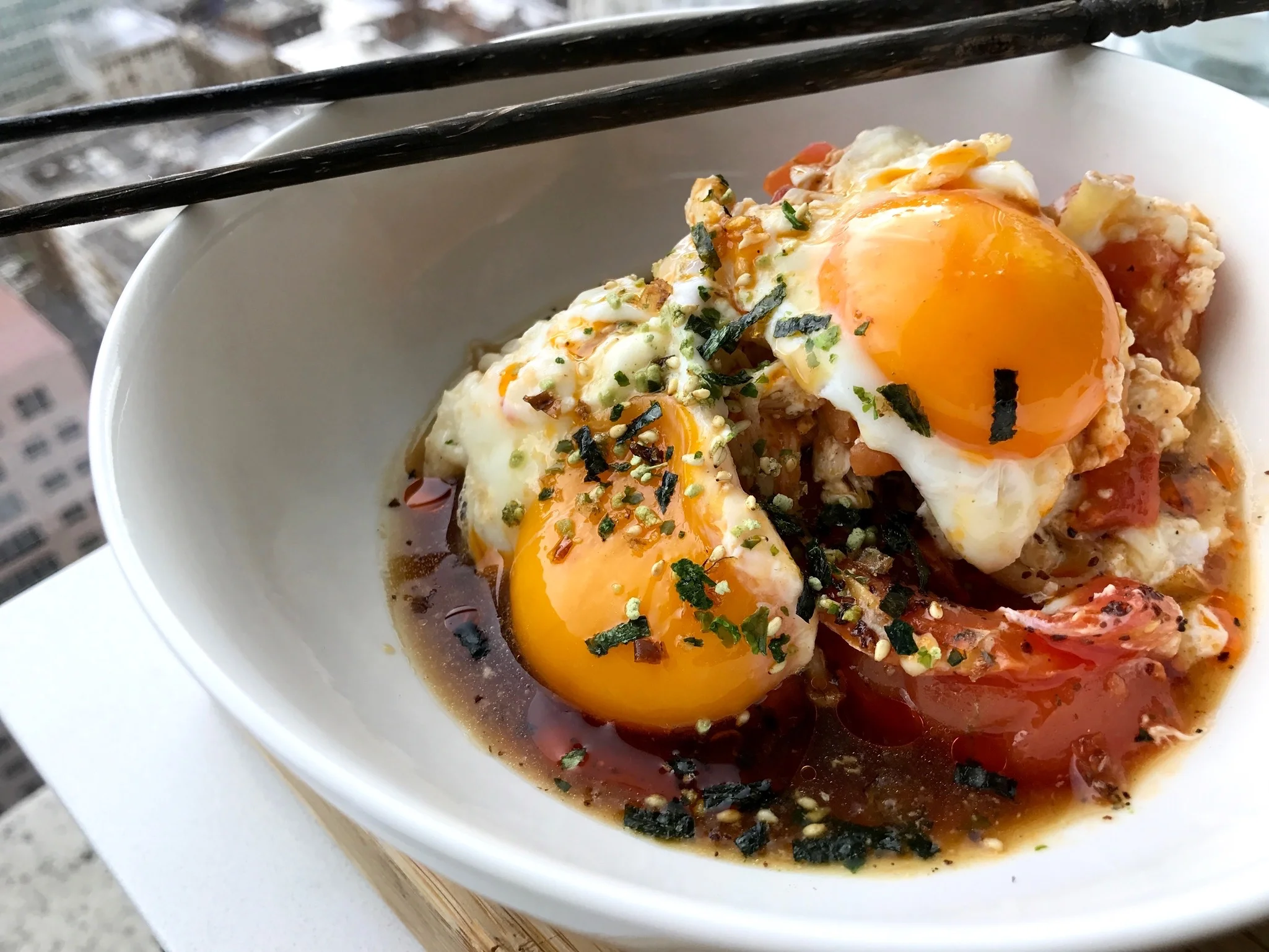 Beautifully cooked golden runny yolks sitting on top a umami bursting pool of tomato enoki broth simmered with ponzu