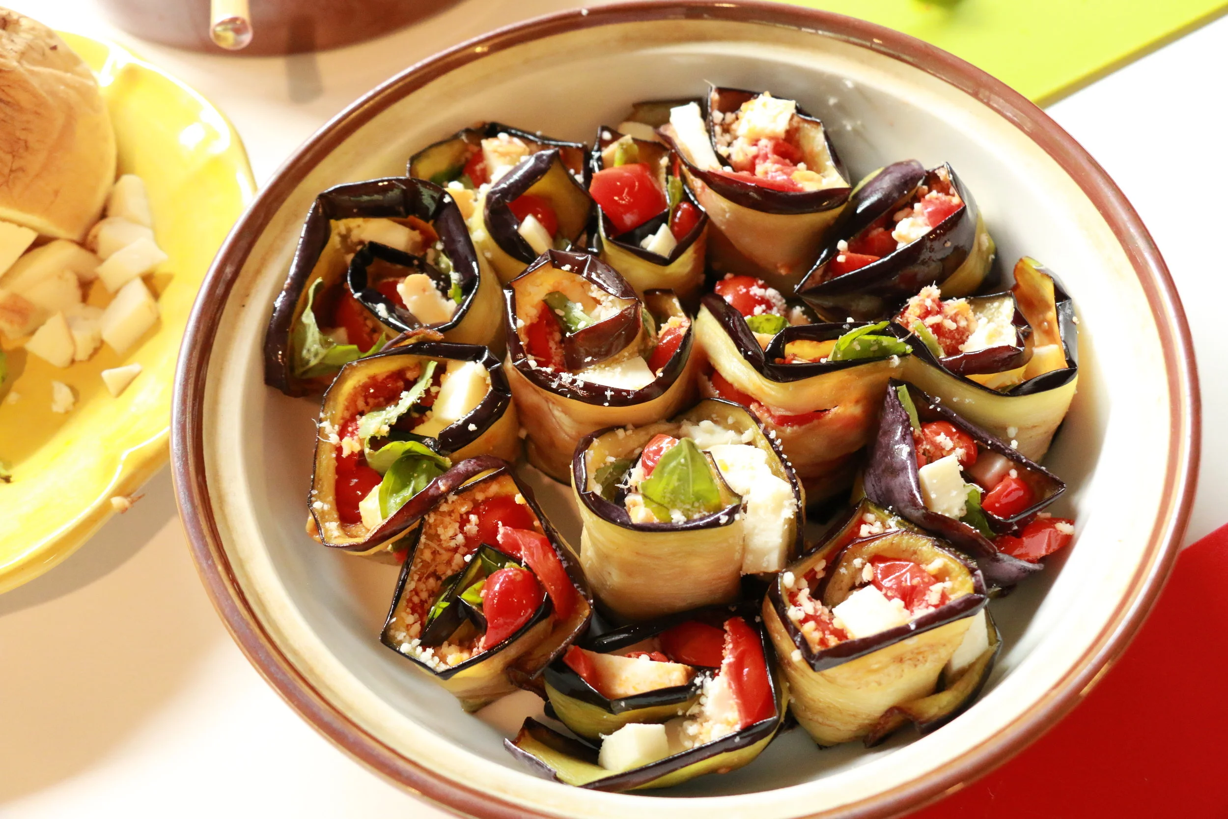 After you finish rolling the eggplant, you get this beautiful arrangement in the shallow bowl, bright and full of color.