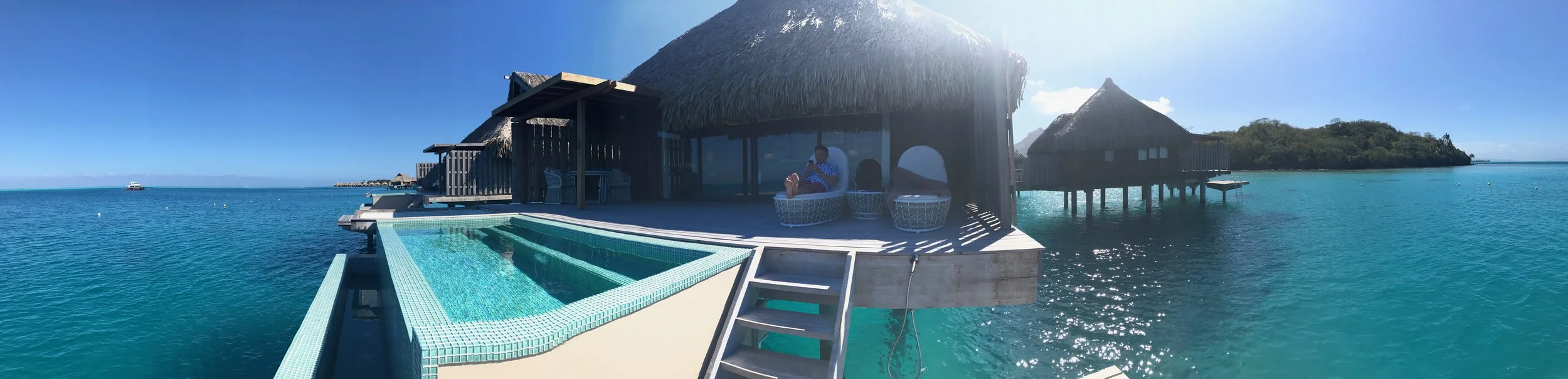 A panorama shot of our villa and my husband sitting on our deck.