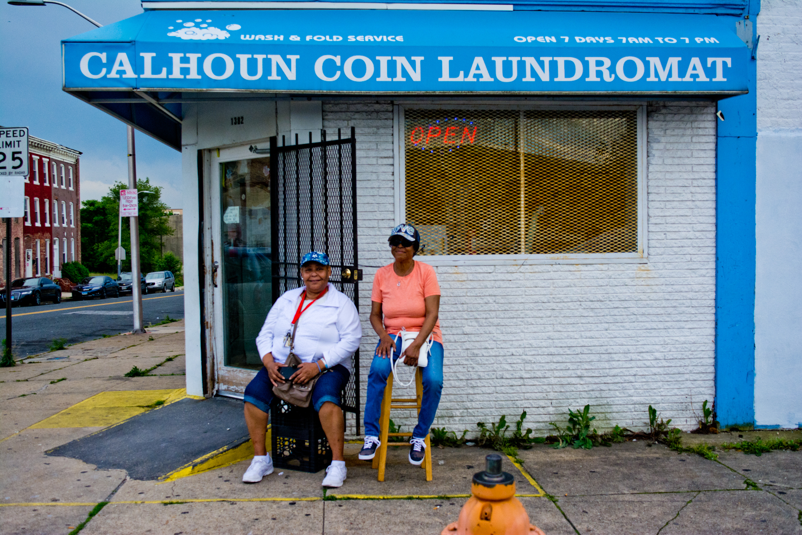 "Talk about the neighborhood! Oh no! Let's not talk about that! *laughter* I've been working at this laundromat for eight years. We have specials Wednesdays and Fridays. We're called the Calhoun Coin Girls. Open seven days a week."