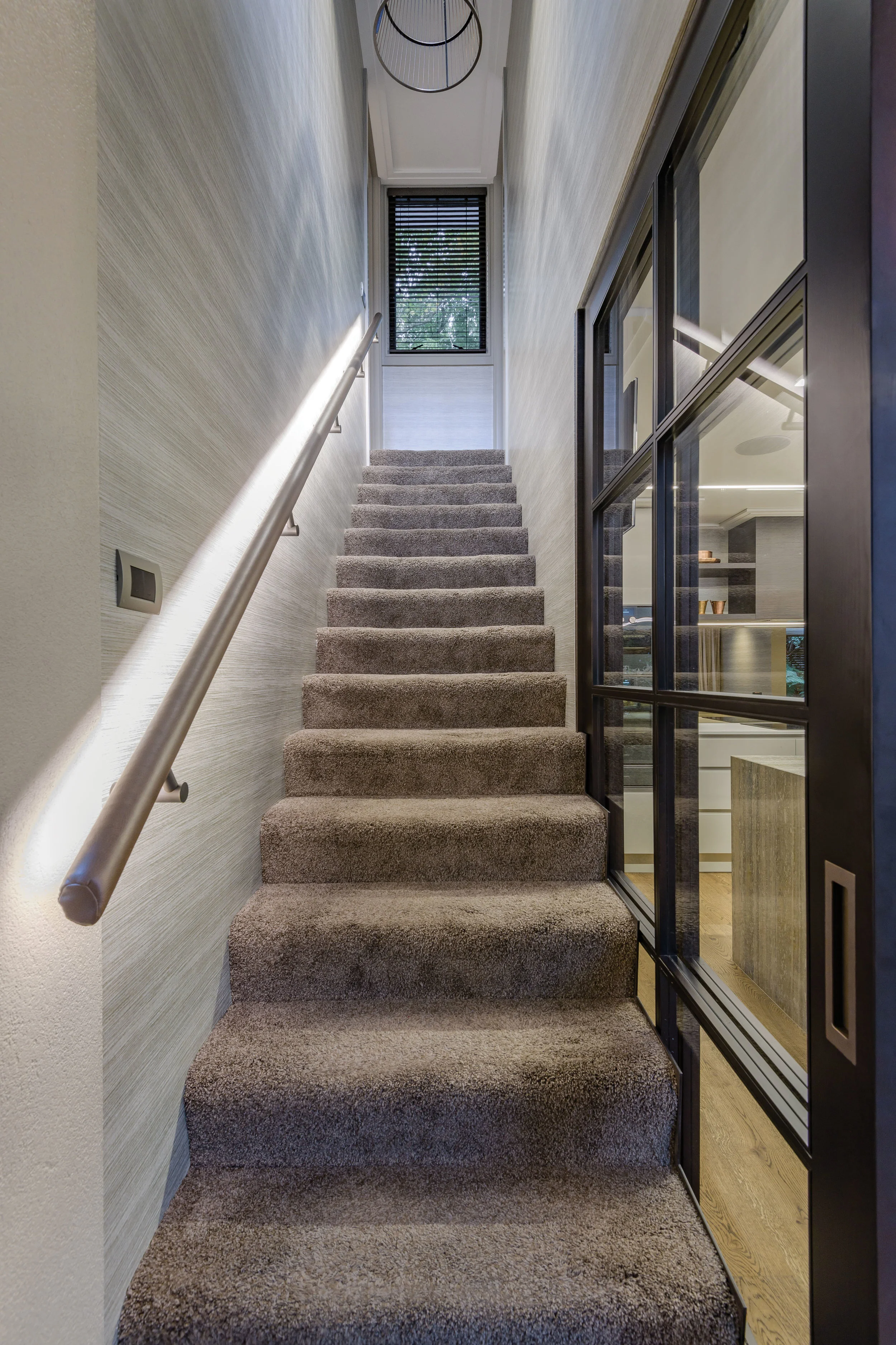 Stairwell Leading to the master suite the leather stairwell handrail was designed by Stewart Harris and made by David Shaw. Hanging from the ceiling is a Henge Luce Solida feature light from David Shaw.