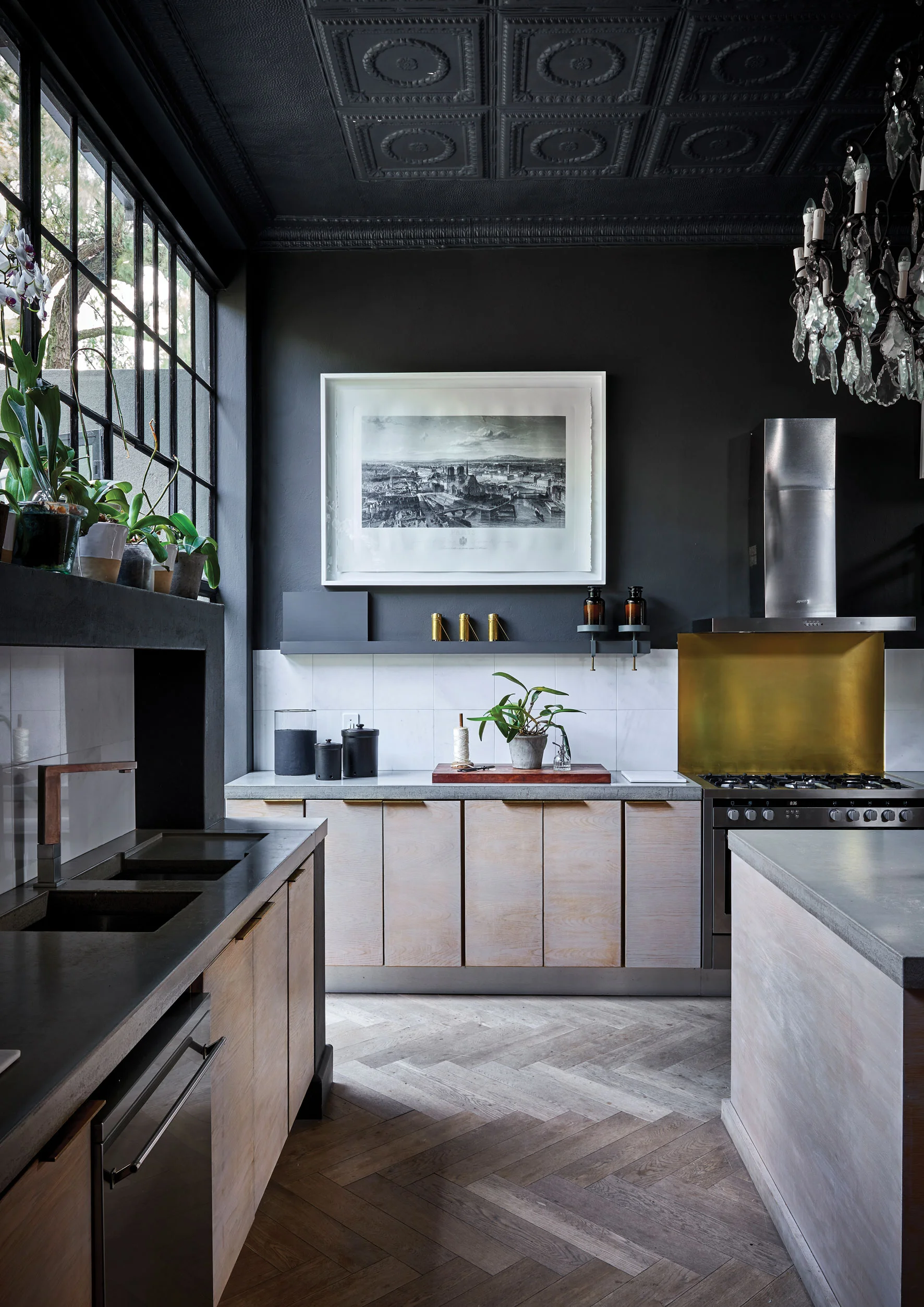KITCHEN In the kitchen, Christian and Anli introduced high pressed-metal ceilings in keeping with the original architectural style typical of the area. The cottage pane windows and profusion of orchids make it feel a little like a greenhouse or conservatory.