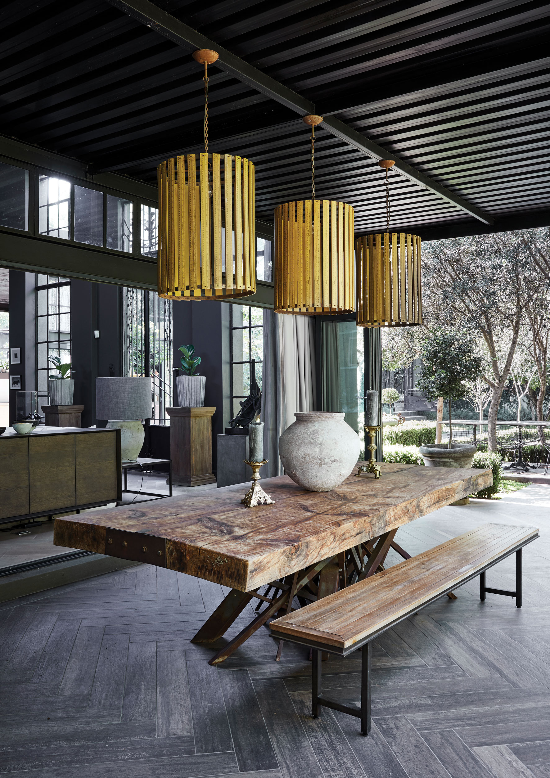 OUTDOOR DINING A covered patio between the main living area and vegetable garden makes for a beautiful outdoor dining area. The outdoor table was custom made by Dahla Hulme. The pendant lights are made with vintage rulers, and came from La Grange Interiors.