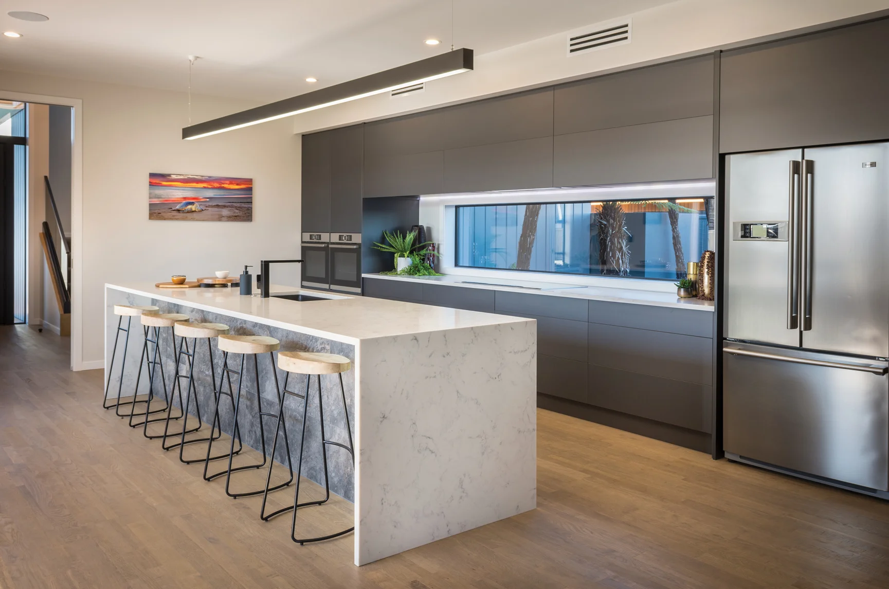 KITCHEN: Misco Joinery supplied and installed the joinery in the beautiful and superbly functional kitchen which features a large kitchen island topped by a Prime Stone benchtop with waterfall ends.