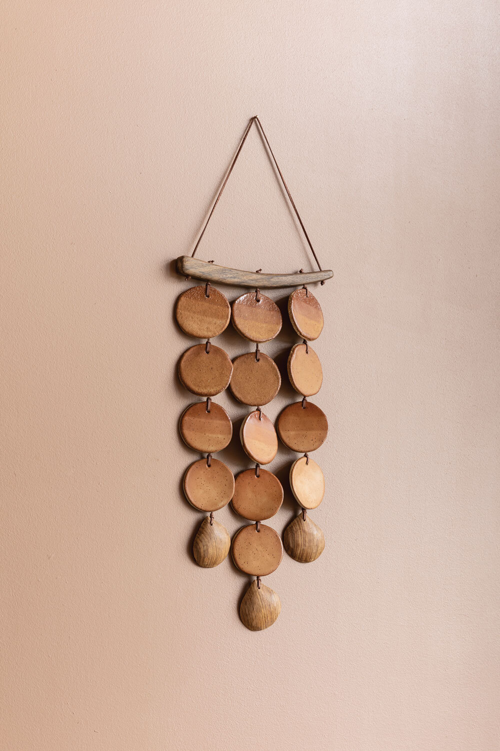 TEXTURAL ADORNMENT Walls can be adorned with more than art – adding texture rather than a 2D image is a way to add some depth to a space. This ceramic piece has movement, picking up light and creating interest through the play with clay and wood.