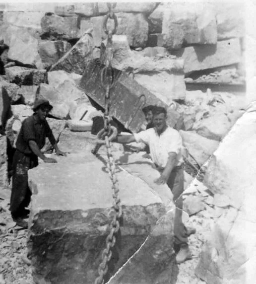 Lumper uppers chaining a 15 ton lump of rock before swinging it onto a trailer.