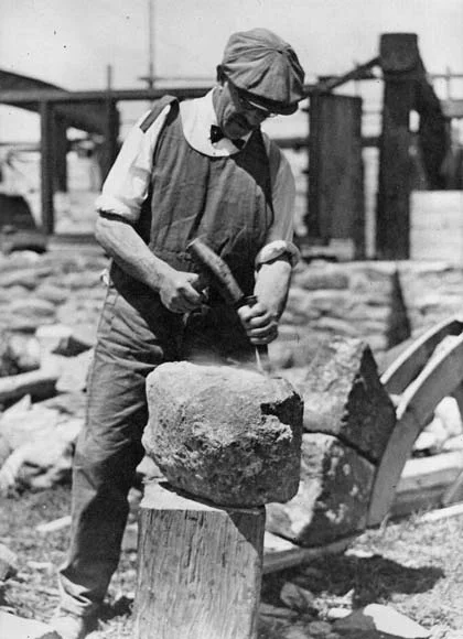 A Victorian scelper chipping a stone into form.