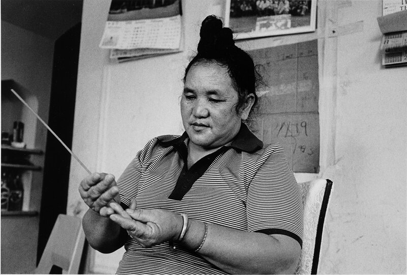 Dia Lee using incense stick to fortell future. Chicago, IL 1983