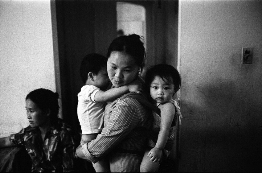 Lee Xiong carrying her children. Chicago, IL 1983