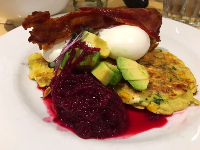 "Sweet As Corn Fritters" Three fritters packed with organic sweet corn, organic feta, courgette and fresh mint served with two poached organic free range eggs, avocado and homemade beetroot relish.